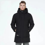 Parka déperlante homme avec extérieur matelassé de couleur noire, avec une capuche, porté par un homme avec les mains dans les poches