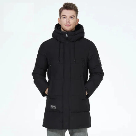 Parka déperlante homme avec extérieur matelassé de couleur noire, avec une capuche, porté par un homme avec les mains dans les poches