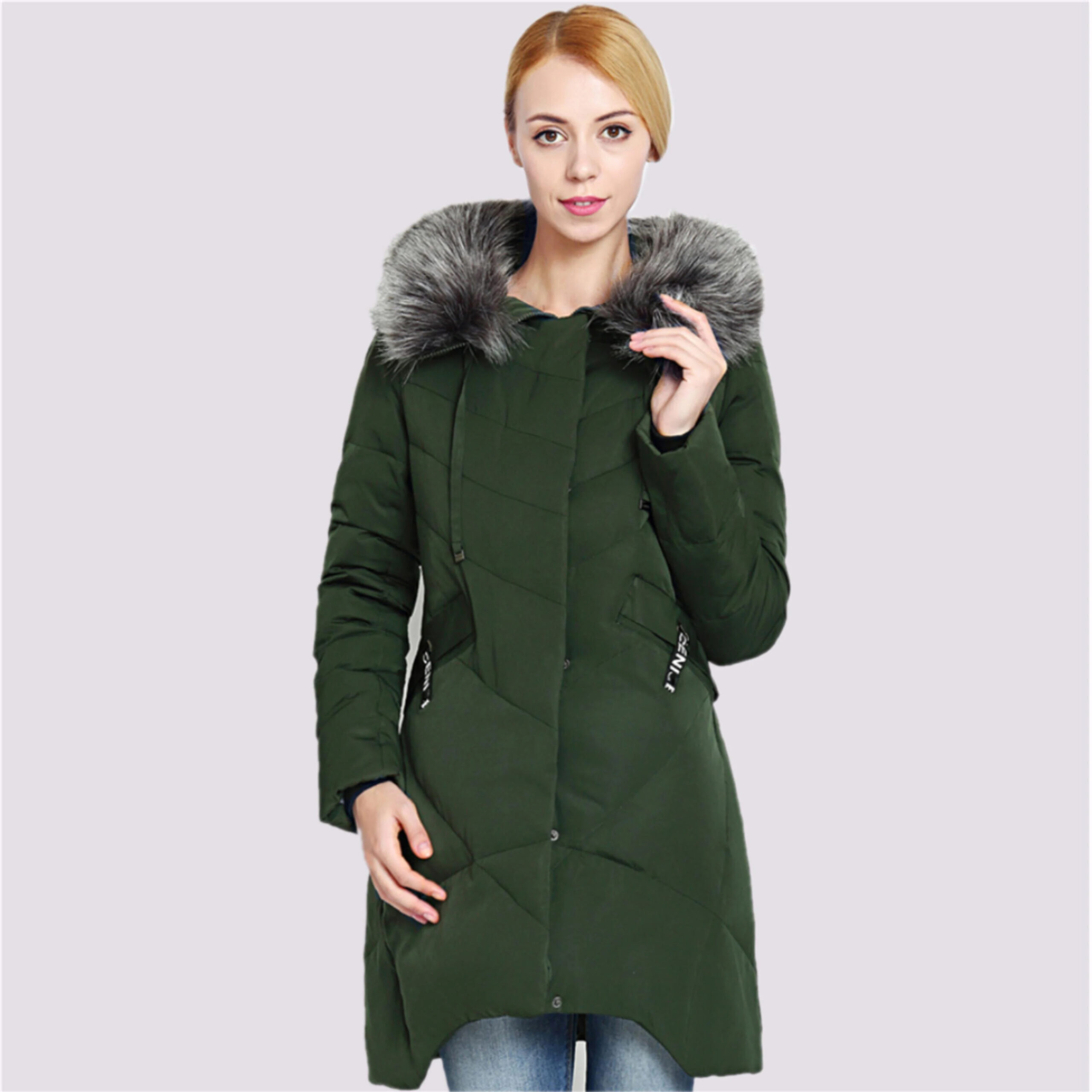 Parka duvet femme avec capuche en fausse fourrure, de couleur verte, portée par une femme. Sur un fond rose clair.