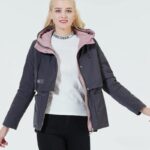 Mannequin femme blonde, portant une parka courte gris foncé avec l'intérieur rose.