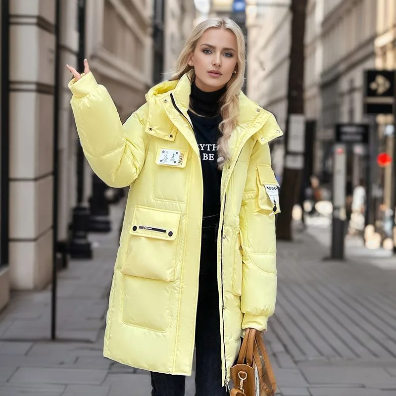 Parka déperlante femme jaune et rembourrée avec capuche Parka déperlante femme jaune et rembourrée avec capuche sur une femme dans la rue
