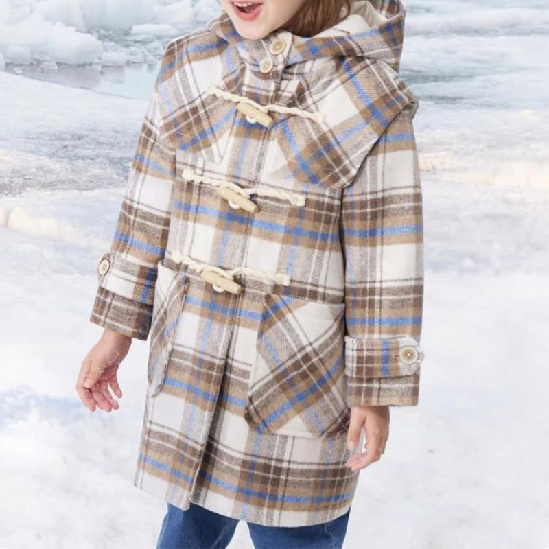 Parka enfant à carreaux avec capuche et grandes poches Petite fille portant une parka à carreau, avec une capuche et deux grandes poches plaquées sur l'avant.