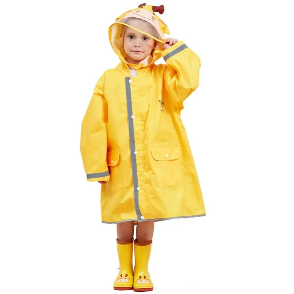 Parka enfant de pluie jaune à capuche girafe Petite fille portant une parka longue jaune, avec une capuche avec une visière transparente, et des bottes de pluies jaunes.