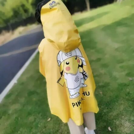 Enfant de dos, debout sur une pelouse qui porte une parka imperméable jaune en forme de poncho avec une capuche.