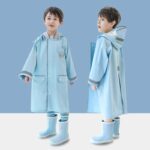 Petit garçon portant une parka K-way longue bleu clair, doté d'une capuche. On le voit de face et de profil.