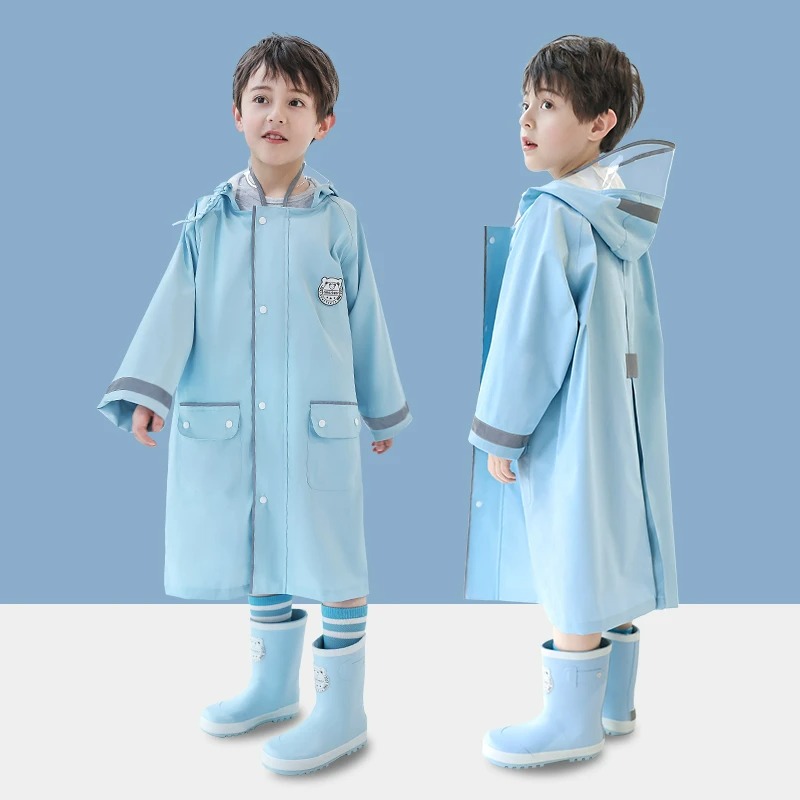Parka enfant K-way à capuche avec des poches Petit garçon portant une parka K-way longue bleu clair, doté d'une capuche. On le voit de face et de profil.