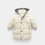 Parka enfant longue style doudoune, beige clair avec capuche et deux poches.