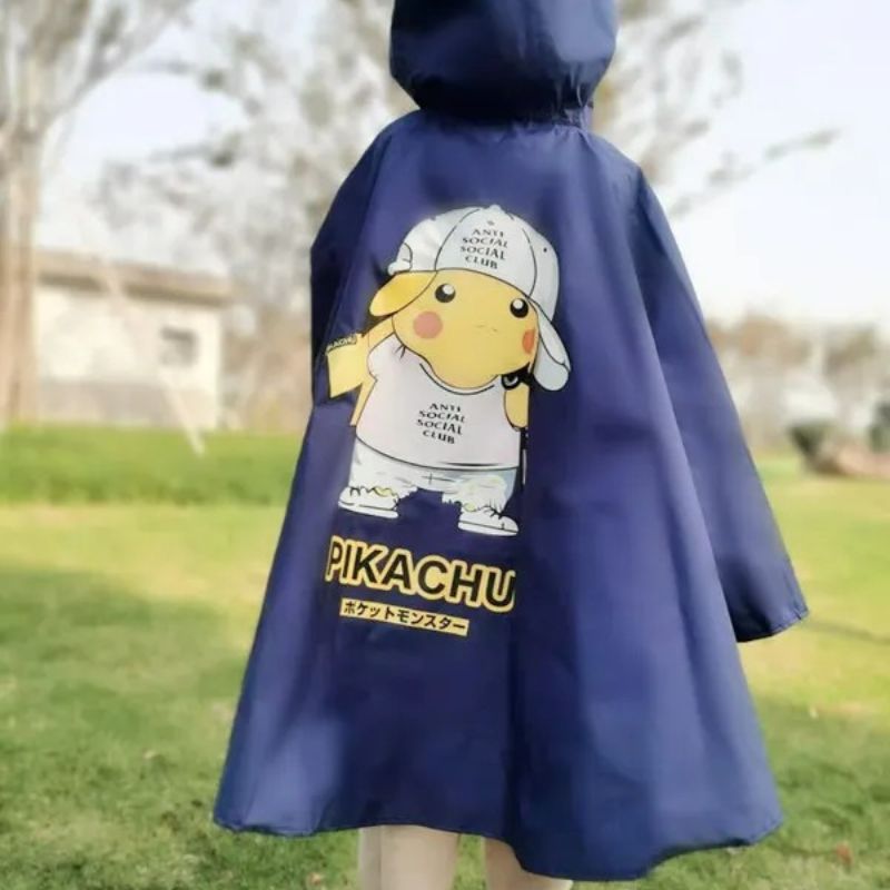 Parka enfant Pikachu imperméable rose en forme de poncho Enfant de dos, debout sur une pelouse qui porte une parka imperméable bleue foncé en forme de poncho avec une capuche.