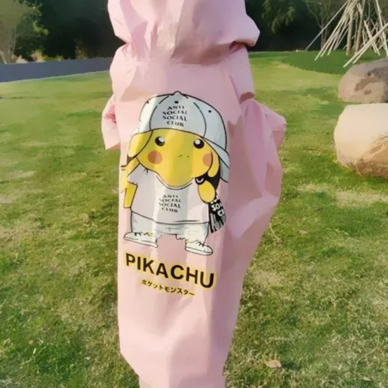 Parka enfant Pikachu imperméable rose en forme de poncho Enfant de dos, debout sur une pelouse qui porte une parka imperméable rose en forme de poncho avec une capuche.