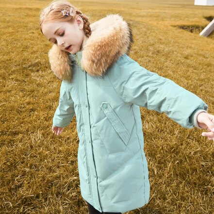 Fille portant une Parka verte avec col en fourrure synthétique épaisse sur la capuche