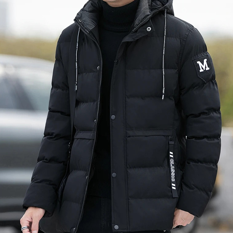 Parka hiver homme matelassée et coupe-vent avec capuche Parka hiver homme matelassée et coupe-vent avec capuche, de couleur noire, porté par un mannequin