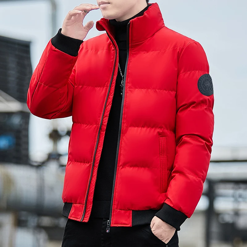 Parka matelassée homme avec col haut et conception épaisse Parka matelassée homme avec col haut et conception épaisse, de couleur rouge portée par un homme debout