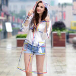 Parka pluie femme transparente avec bords multicolores sur une femme sur fond d'une rue