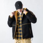 Parka reversible homme avec capuche noire et jaune, porté par uèn homme avec une casquette