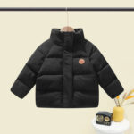 Parka enfant matelassée et coupe-vent sur fond beige